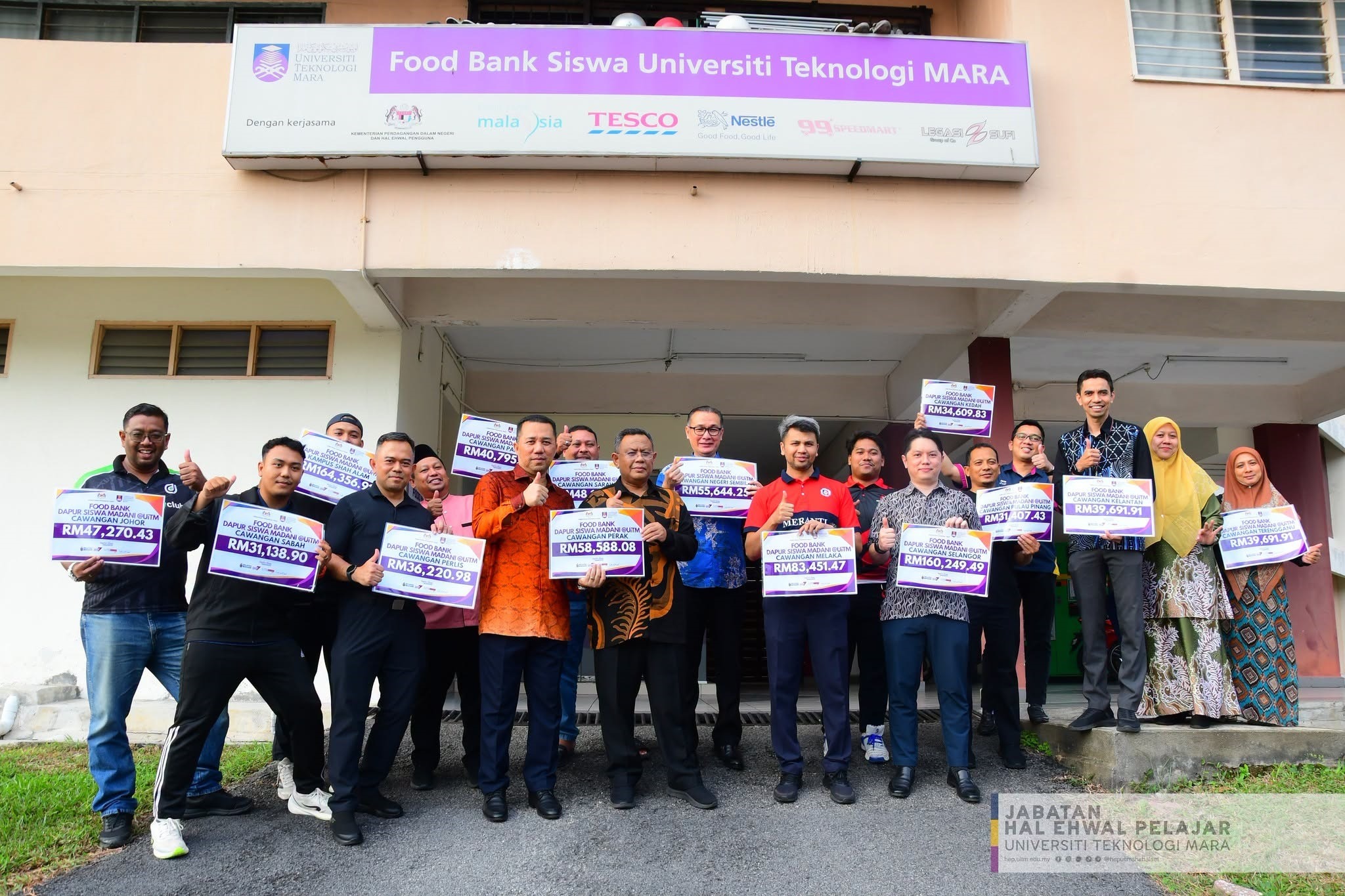 Sekumpulan pegawai UiTM bergambar sambil memegang plakad yang memaparkan jumlah peruntukan Food Bank Dapur Siswa MADANI mengikut cawangan.